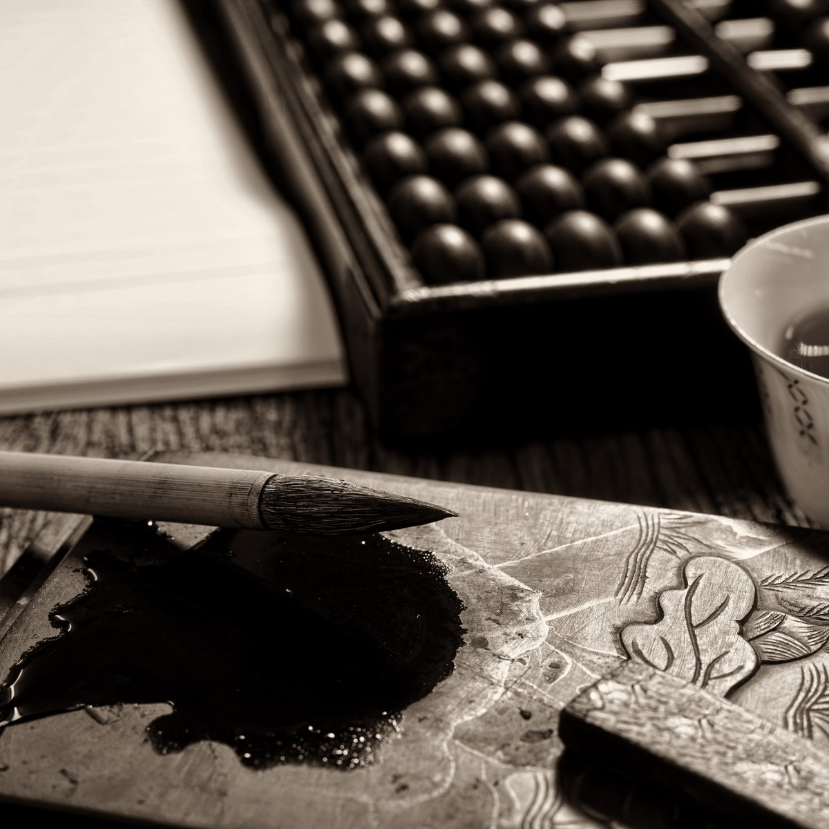 Inkwell with ink and brush on a wooden desk to illustrate books from Fern Jean-Joseph